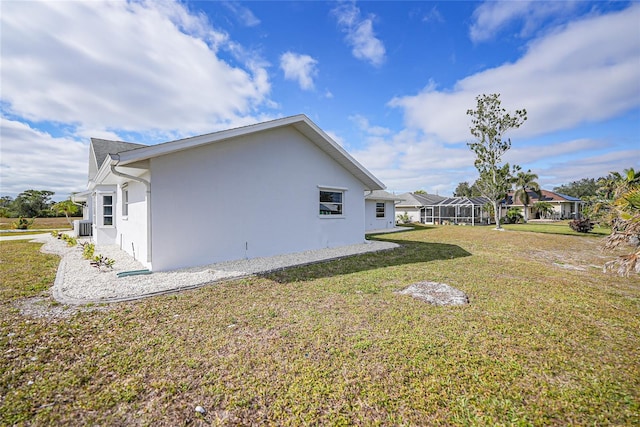 view of side of property with a lawn and central AC