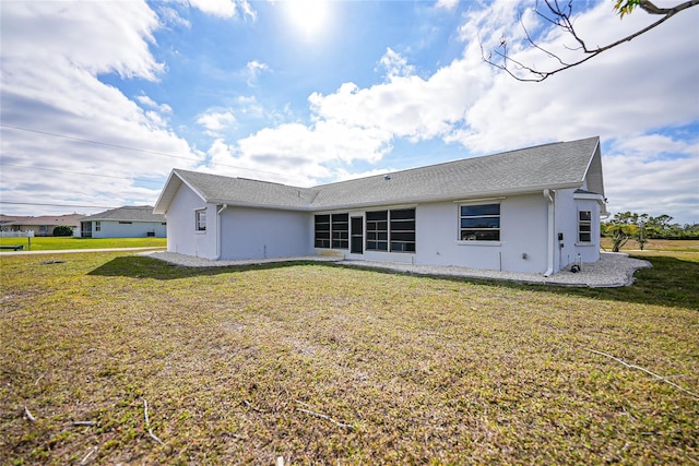 rear view of property featuring a yard