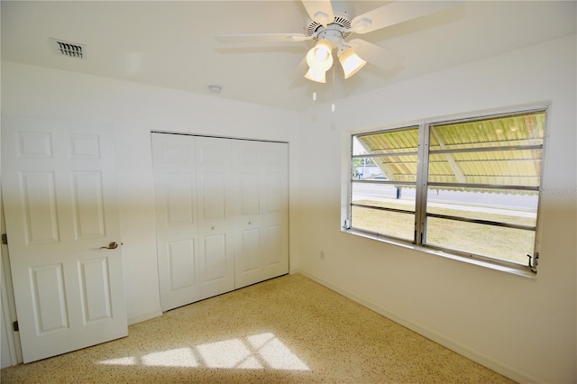 unfurnished bedroom featuring ceiling fan and a closet