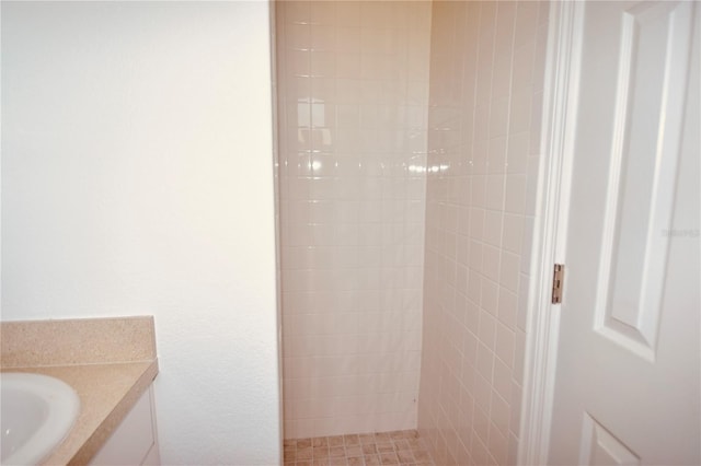 bathroom with vanity and a tile shower