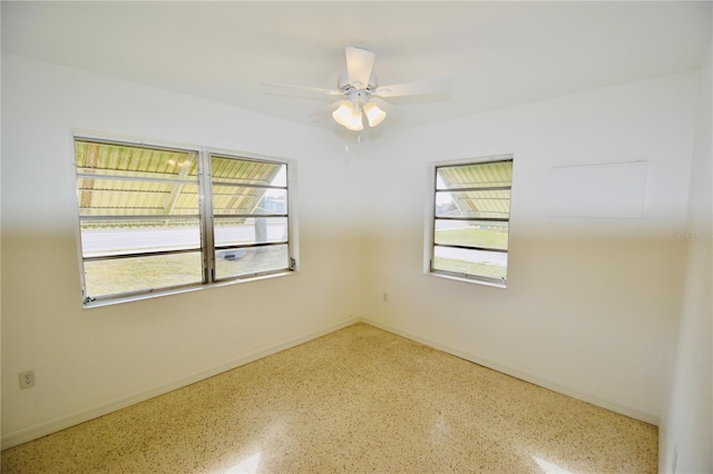 empty room featuring ceiling fan and plenty of natural light