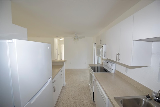 kitchen with white appliances, white cabinetry, ceiling fan, and sink