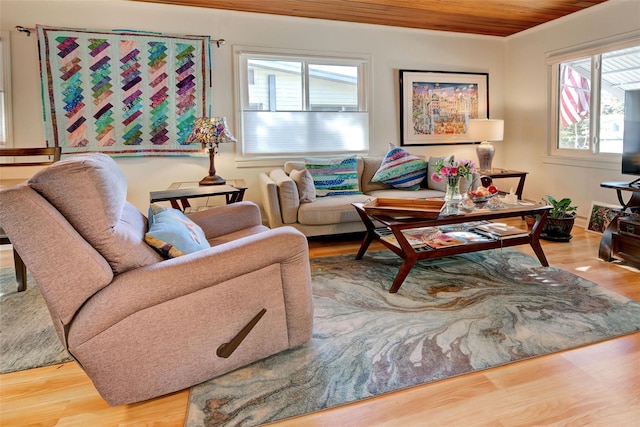 living room featuring wood ceiling, ornamental molding, and light hardwood / wood-style flooring