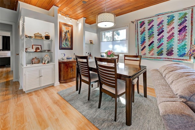 dining room with crown molding, wood ceiling, and light wood-type flooring