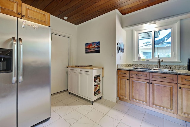 kitchen featuring light stone countertops, stainless steel fridge, wood ceiling, crown molding, and sink