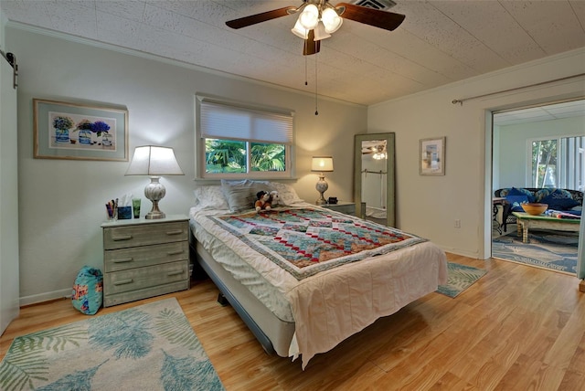 bedroom with ceiling fan, crown molding, and light hardwood / wood-style flooring