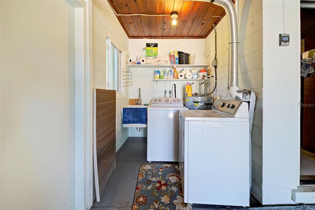 laundry room featuring washing machine and dryer, wooden ceiling, and sink