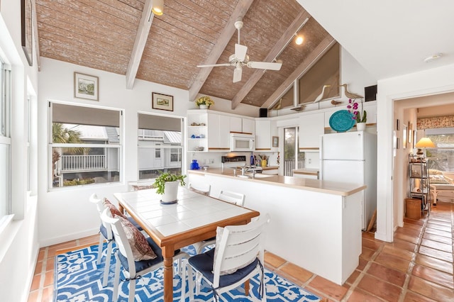 dining area featuring ceiling fan, beamed ceiling, high vaulted ceiling, light tile patterned floors, and wooden ceiling