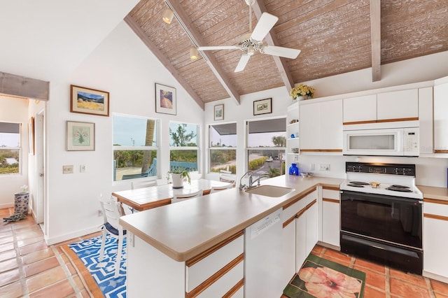 kitchen with beam ceiling, kitchen peninsula, sink, and white appliances