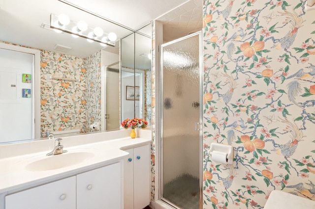 bathroom featuring vanity and a shower with door