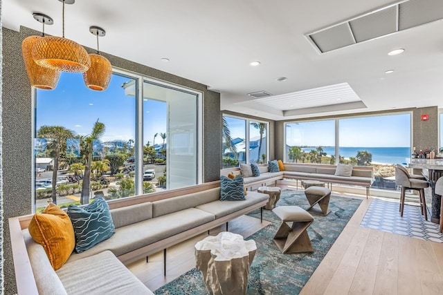 living room with plenty of natural light, a water view, and hardwood / wood-style floors