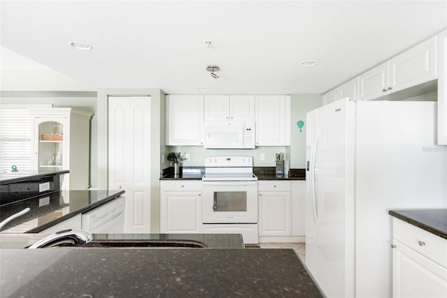 kitchen featuring white appliances, white cabinetry, dark stone countertops, and light tile patterned floors