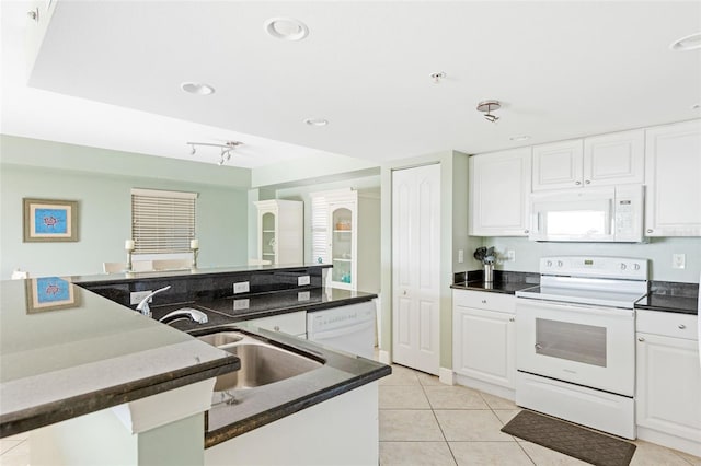 kitchen featuring white appliances, light tile patterned floors, and white cabinetry