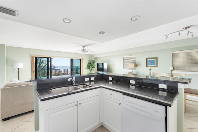 kitchen with an island with sink, light tile patterned floors, white dishwasher, sink, and white cabinetry