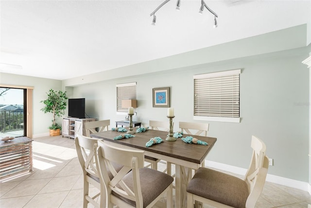 dining area with track lighting and light tile patterned flooring