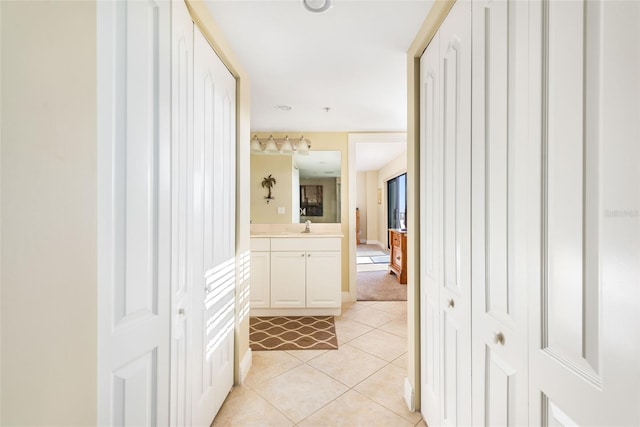 corridor with sink and light tile patterned flooring