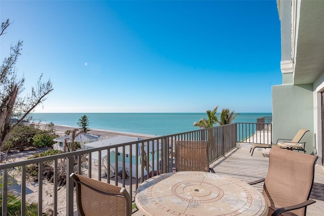 balcony featuring a beach view and a water view