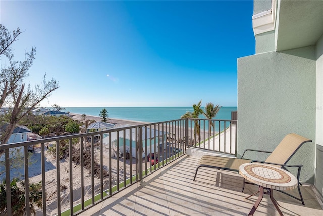 balcony featuring a beach view and a water view