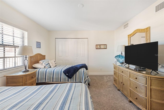 bedroom with multiple windows, a closet, and light carpet