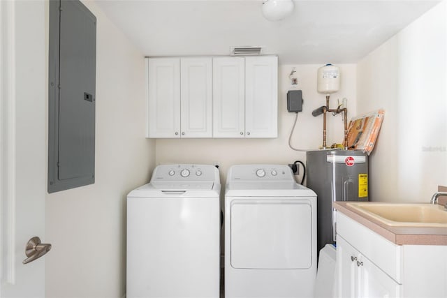 clothes washing area with cabinets, electric water heater, electric panel, sink, and washing machine and clothes dryer