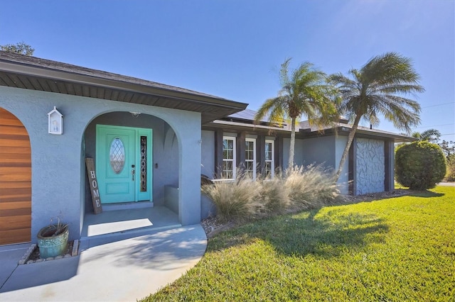 property entrance featuring a garage and a lawn