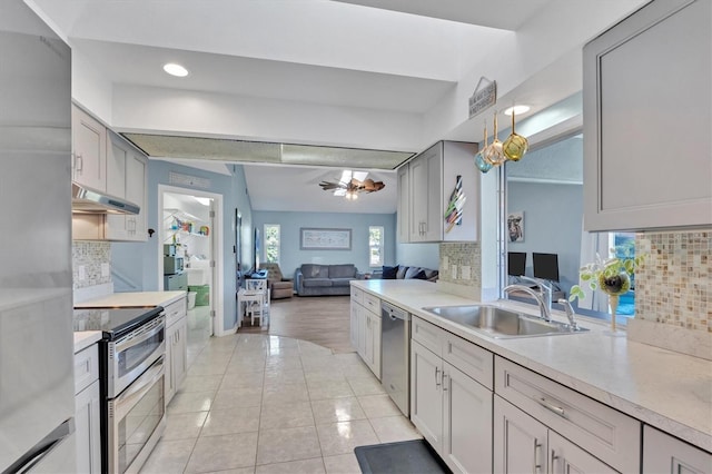 kitchen featuring stainless steel appliances, gray cabinets, light countertops, a sink, and under cabinet range hood