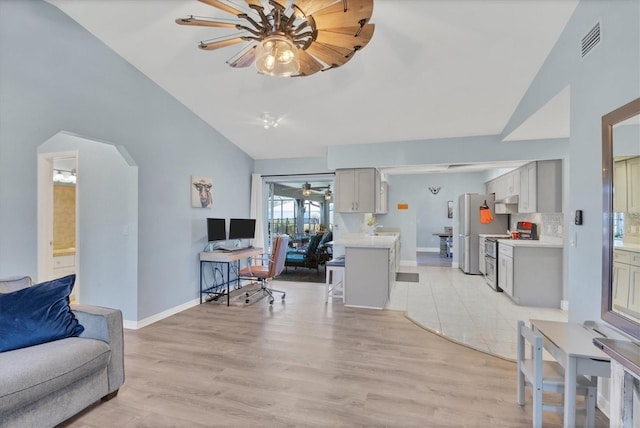 living area with baseboards, visible vents, arched walkways, a ceiling fan, and light wood-style flooring