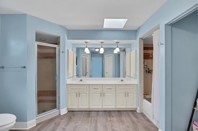 bathroom featuring a bath, a skylight, a sink, and a stall shower