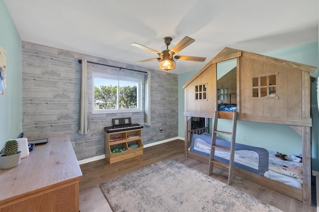 bedroom with ceiling fan, dark wood-style flooring, and baseboards