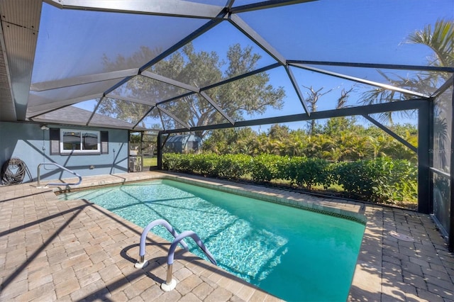 pool featuring glass enclosure and a patio area