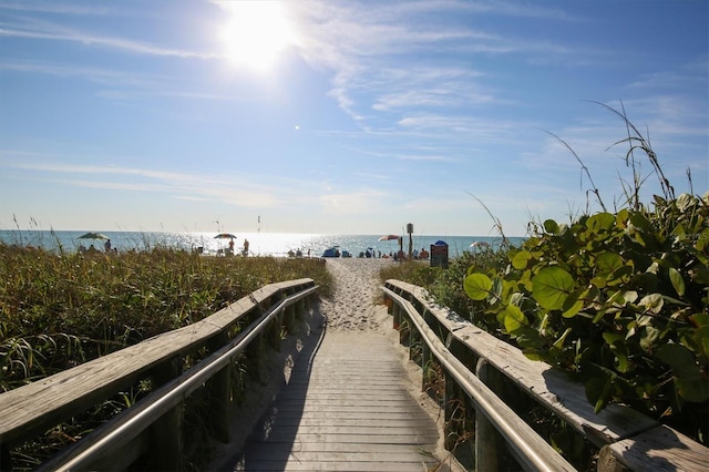 surrounding community with a view of the beach and a water view