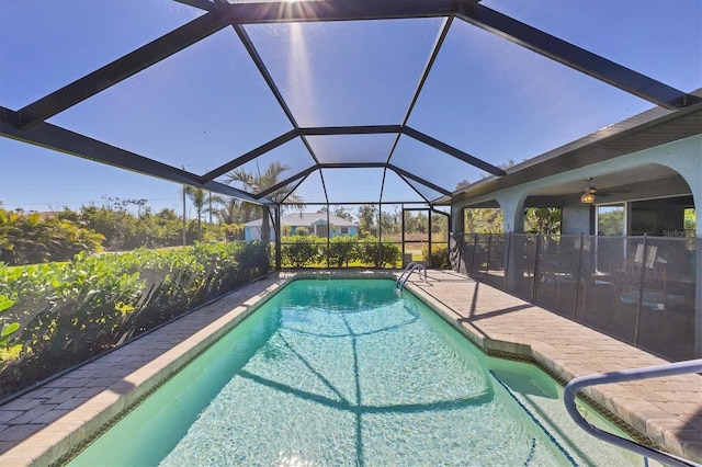 pool featuring glass enclosure and a patio