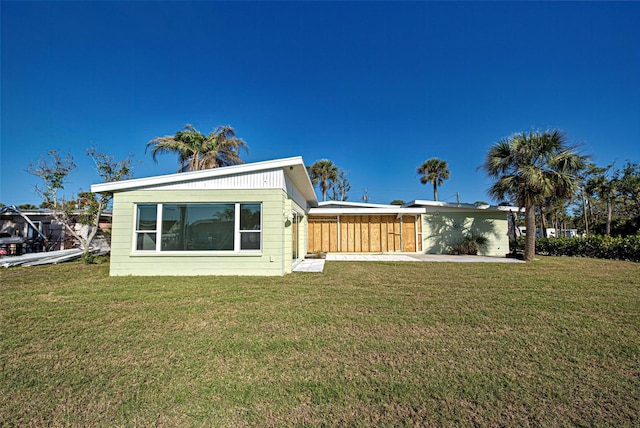 rear view of house featuring a lawn