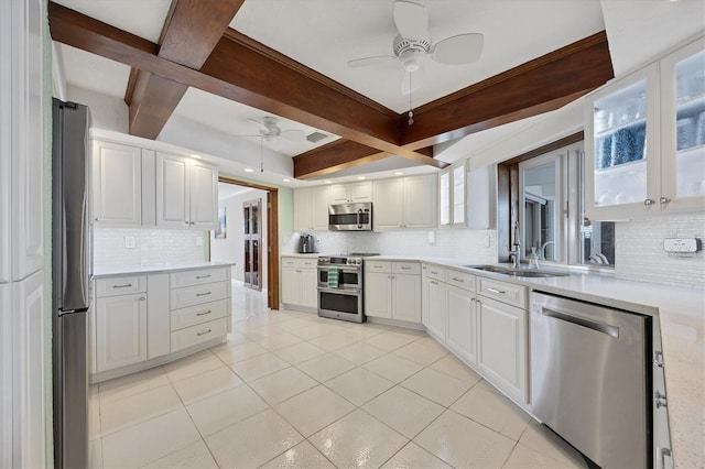 kitchen featuring beamed ceiling, backsplash, white cabinetry, and stainless steel appliances