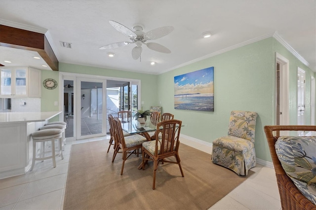 tiled dining area with crown molding and ceiling fan