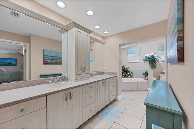 bathroom with tile patterned flooring, vanity, ceiling fan, and a washtub