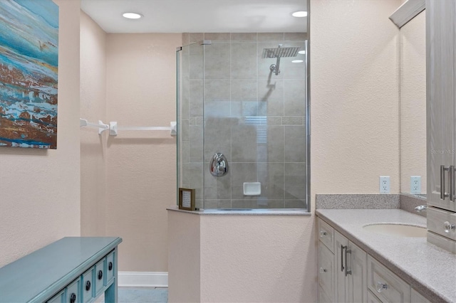 bathroom with a tile shower and vanity