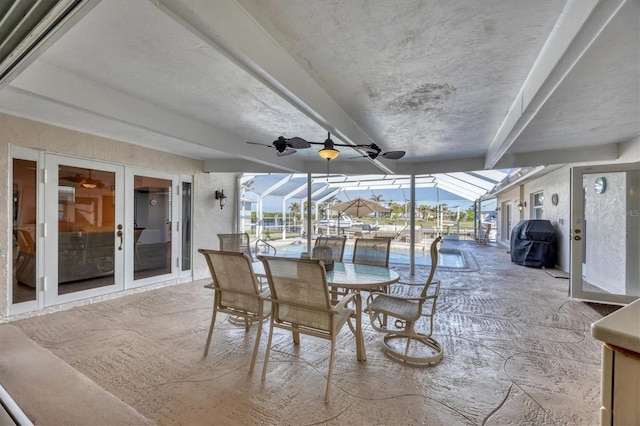 view of patio featuring glass enclosure, ceiling fan, french doors, and area for grilling