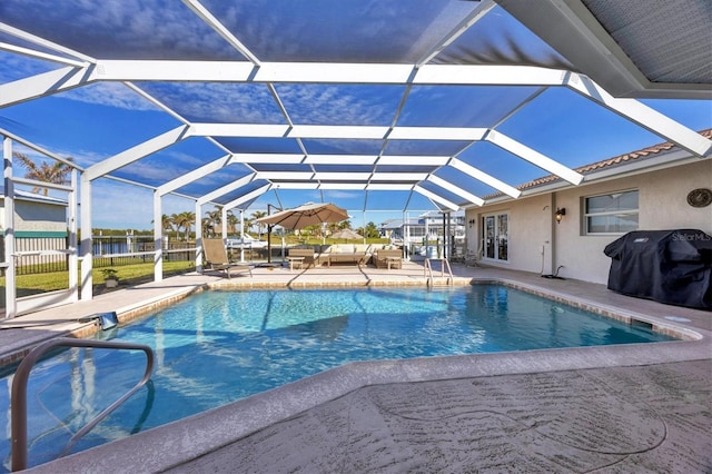 view of pool with a lanai, a grill, and a patio