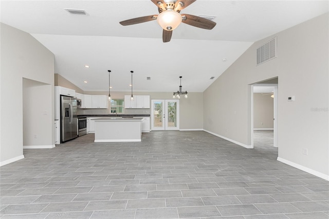 kitchen featuring white cabinetry, stainless steel appliances, a kitchen island, decorative light fixtures, and vaulted ceiling