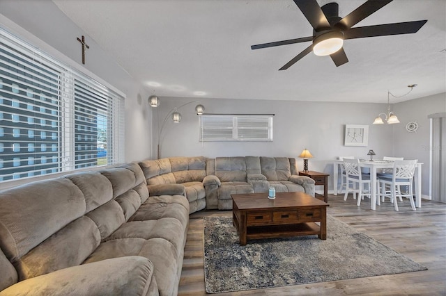 living room with hardwood / wood-style flooring and ceiling fan with notable chandelier