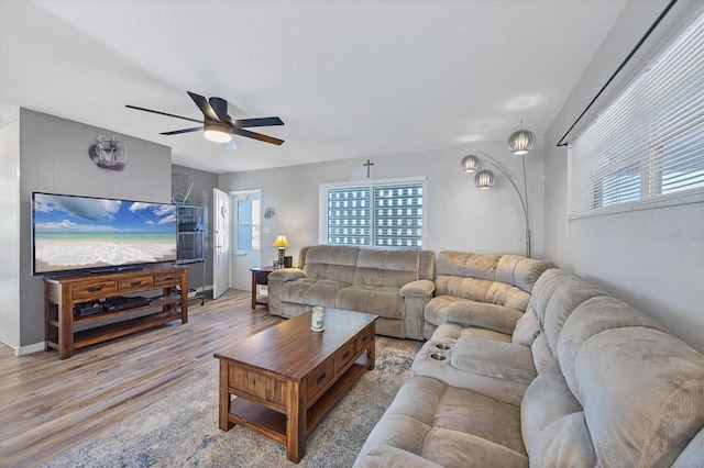 living room featuring a textured ceiling, light hardwood / wood-style floors, and ceiling fan