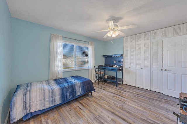 bedroom with ceiling fan, light hardwood / wood-style floors, and a textured ceiling