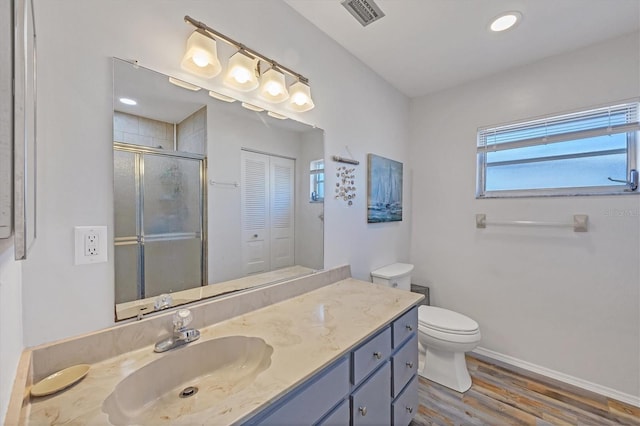 bathroom with toilet, vanity, an enclosed shower, and hardwood / wood-style flooring