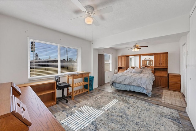 bedroom featuring ceiling fan, light hardwood / wood-style floors, and a textured ceiling