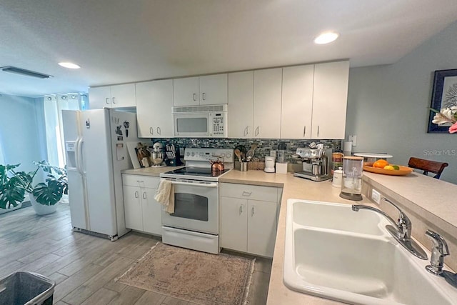 kitchen featuring sink, tasteful backsplash, light hardwood / wood-style flooring, white appliances, and white cabinets