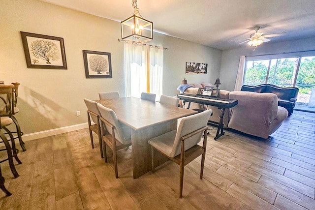 dining space with hardwood / wood-style floors and ceiling fan with notable chandelier