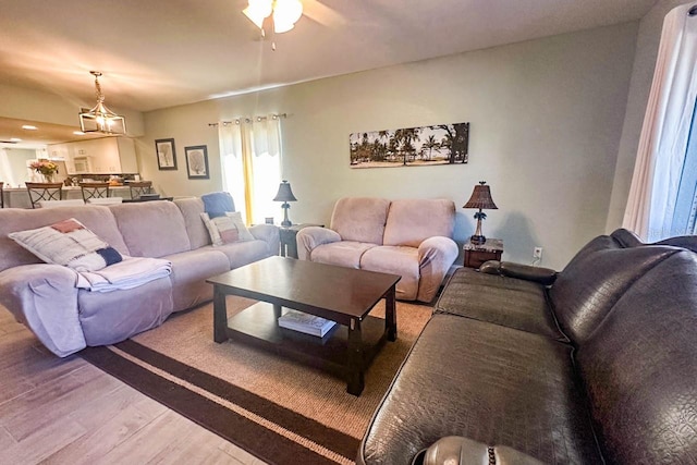 living room featuring hardwood / wood-style floors and ceiling fan with notable chandelier