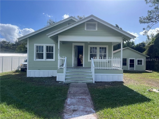 bungalow-style home with covered porch and a front yard