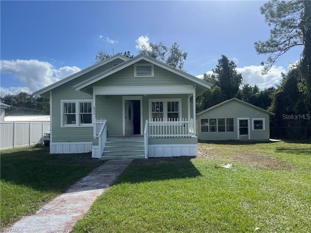 bungalow with covered porch and a front lawn